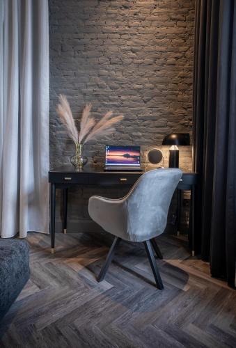 a chair in front of a desk with a laptop at Gagos Suites - Center in Larisa