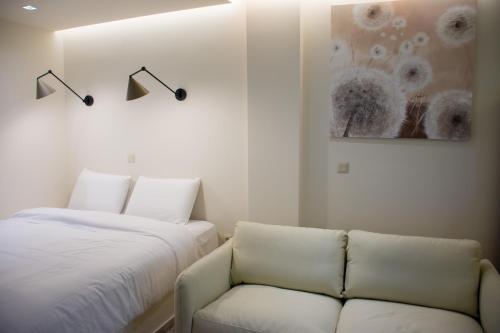a bedroom with a bed and a couch and a painting at Pixie Studio Athens in Athens