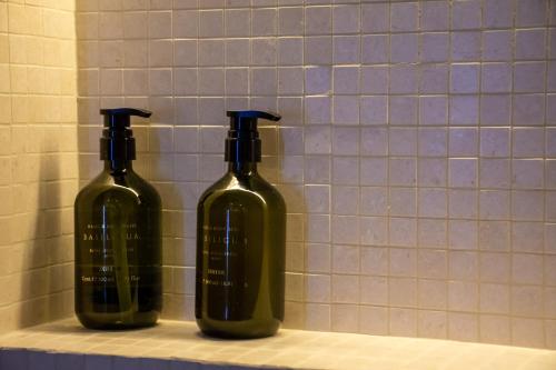two wine bottles sitting on a shelf in a bathroom at Pixie Studio Athens in Athens