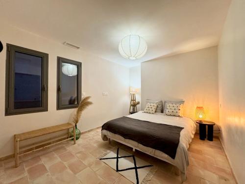 una camera con letto e luce a ciondolo di Villa familiale avec piscine hyper centre a Valras-Plage