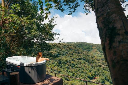 a man in a bath tub in the forest at Amalú Luxury View Cabins in Monteverde Costa Rica