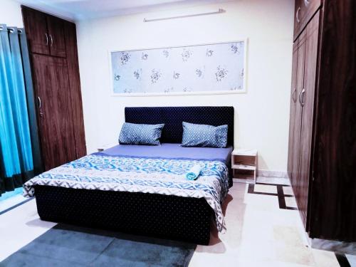 a bedroom with a bed with a blue comforter at 2 Bed Luxury House Islamabad Rawalpindi in Rawalpindi