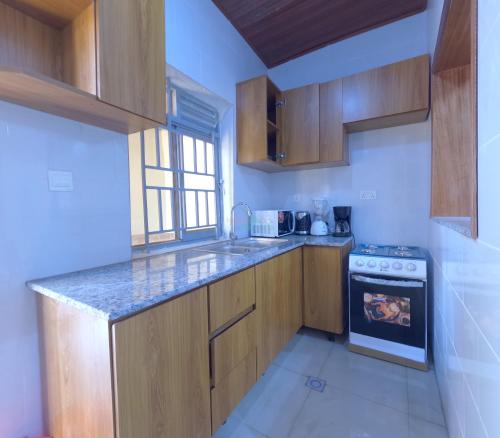 a kitchen with wooden cabinets and a stove at Home2home in Kigali