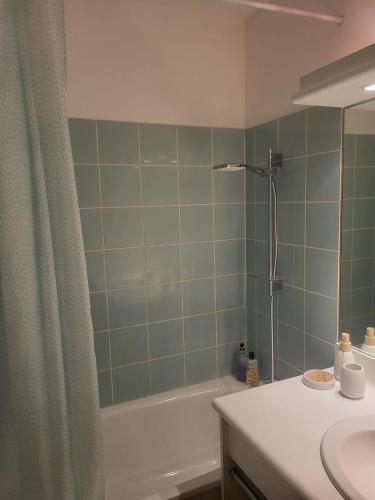 une salle de bain avec un lavabo, une baignoire et une douche dans l'établissement Appartement dans une résidence avec piscines, à Carantec