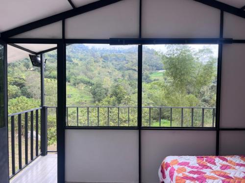 a room with a view of a bed and a balcony at Cabaña del Rio in Choachí