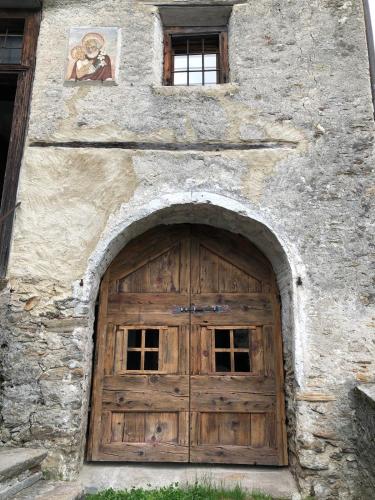 a large wooden door in a stone building at Bijou aus dem 18 Jahrhundert im Maggiatal in Fusio