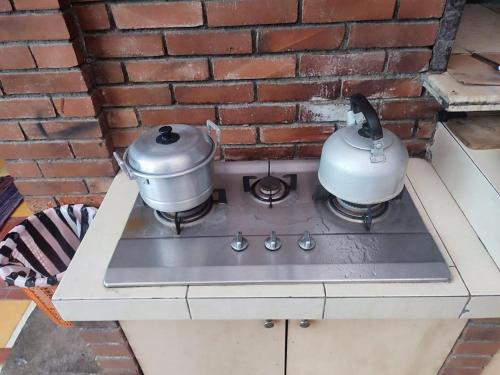 two pots and pans sitting on top of a stove at Homestay AYODYA in Prambanan