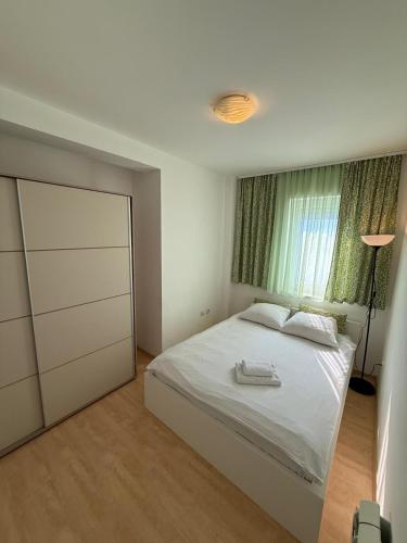 a bedroom with a white bed and a window at Villa Jelena in Banja Koviljača