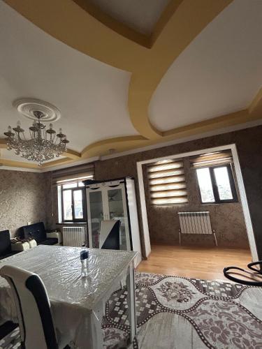 a dining room with a table and a living room at Ideal apartments for family in Ganja