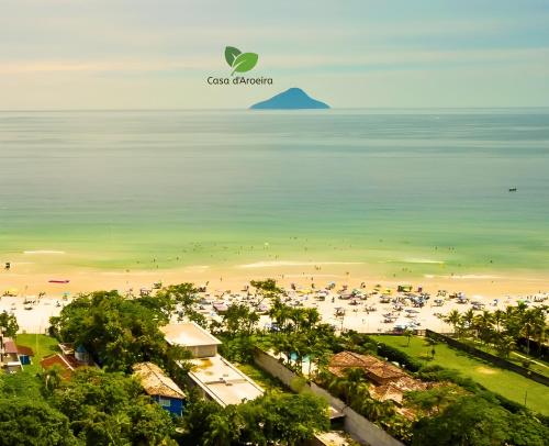 a view of a beach with people in the water at Casa d'Aroeira Residencial Boutique - Centro de Juqueí - 2 quadras do mar - Serviço de Praia - Roupa de Cama 600 fios algodão Egípcio - Toalhas Banho e Praia - Tudo Novo - Estacionamento Interno - Cozinha - Consulte unidades com Ofurô Hidro e Cromoterapia in Juquei