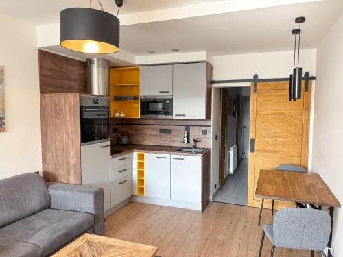 a kitchen and living room with a couch and a table at Apartmán Čertovka, Harrachov in Harrachov