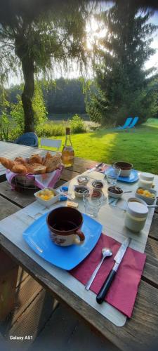 a picnic table with food and bread on it at La cabane in Lonny