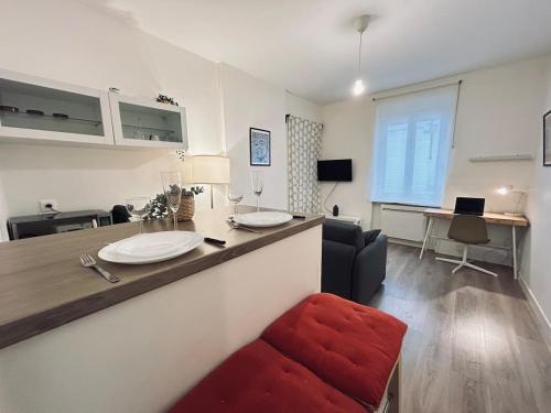 - un salon avec un comptoir et une chaise rouge dans l'établissement Duruy D studio confort proche piscine et patinoire, à Reims