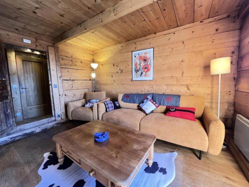 un salon avec un canapé et une table dans l'établissement Résidence La Ferme Des Frasses - Mazot de charme MAE-3421, à Notre-Dame-de-Bellecombe