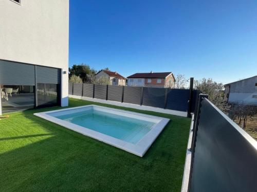 Πισίνα στο ή κοντά στο Villa V, ROOMS WITH PRIVATE BATHROOM, SHARED KITCHEN, LIVING ROOM AND GARDEN WITH HEATED POOL, Privlaka, Zadar
