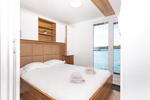 a bedroom with a bed with towels on it at Hausboot Astrid - Floating House in Pula