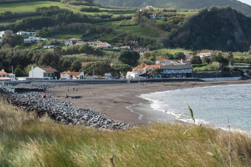 a beach with people on the sand and water at Casa da Praya in Horta
