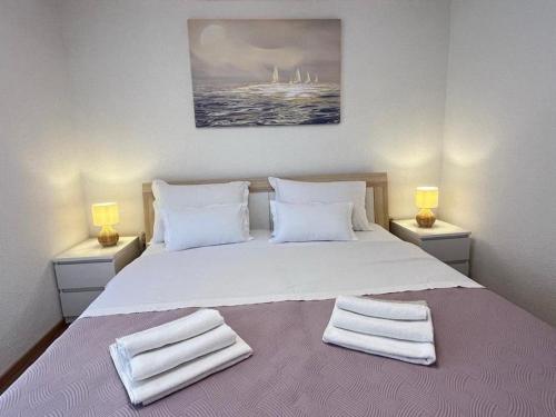 a bedroom with a large white bed with towels on it at Villa Naledi in Pašman