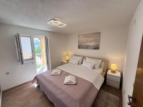 a bedroom with a large bed and a window at Villa Naledi in Pašman