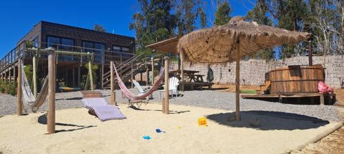 a playground with a swing set and an umbrella at Algarrobo Tinaja Caliente Privada Lista para Disfrutar in Tunquen