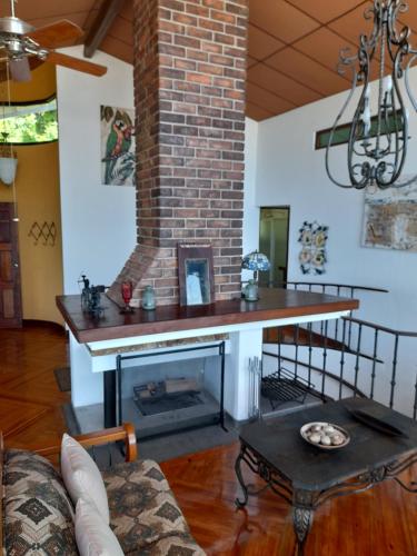 a living room with a fireplace and a table at Jungle Lodge Santis Panama in Bajo Grande
