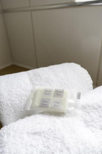 a pile of white towels on top of a bed at Riverview House in Glasgow