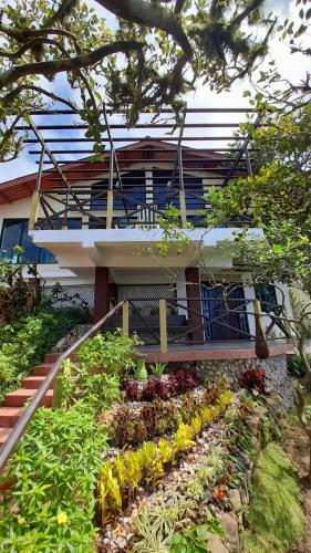a house with a flower garden in front of it at Jungle Lodge Santis Panama in Bajo Grande