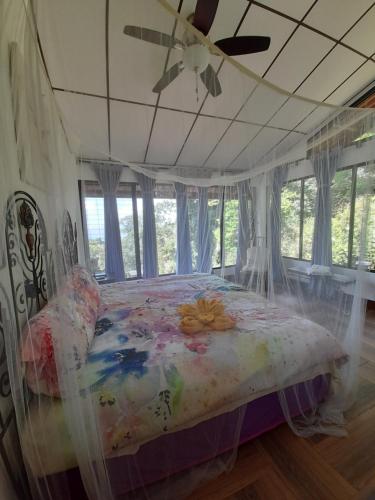 a bed in a bedroom with a ceiling fan at Jungle Lodge Santis Panama in Bajo Grande