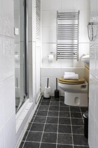 a white bathroom with a toilet and a shower at Riverview House in Glasgow