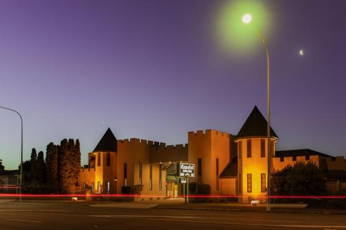 a building with a street light on the side of a street at Camelot Motor Lodge and Conference Centre in Palmerston North