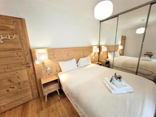 une chambre d'hôtel avec un grand lit et un miroir dans l'établissement Résidence La Croisette - Très bel appartement, spacieux, lumineux, proximité immédiate centre MAE-0011, aux Gets