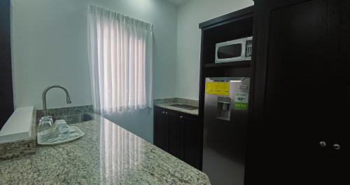a kitchen with a counter top and a microwave at Real Guanacaste in San Pedro Sula