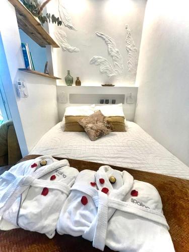 deux serviettes sur un lit dans une chambre dans l'établissement Détente absolue suite luxueuse avec balnéo et PS5, à Saint-Vincent-de-Barbeyrargues