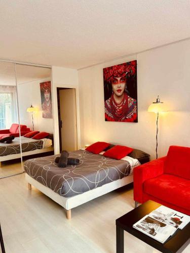 a bedroom with a bed and a red couch at Studio RED MASTER in Saint-Tropez