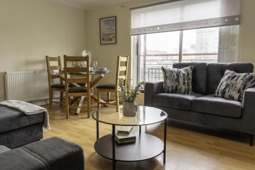 a living room with a couch and a table at Riverview House in Glasgow