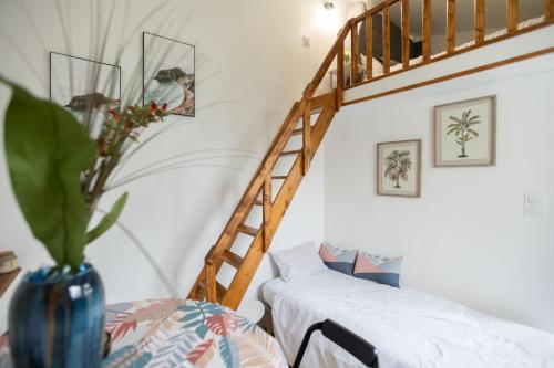 un salon avec un escalier et un vase fleuri dans l'établissement Joli appartement à Montmagny, à Montmagny