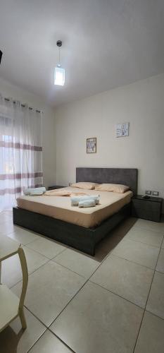 une chambre avec un grand lit dans une pièce dans l'établissement Double room with shared bathroom, à Tirana