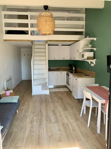 une cuisine et une salle à manger avec une mezzanine et une table dans l'établissement Appartement cosy au calme - Seignosse Les bourdaines, à Seignosse