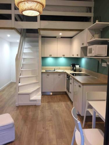 une cuisine avec un escalier en colimaçon dans une pièce dans l'établissement Appartement cosy au calme - Seignosse Les bourdaines, à Seignosse