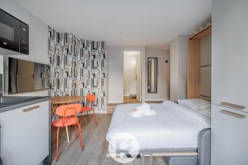 une chambre avec un lit et une table et une cuisine dans l'établissement R'Apparts Latelier D'exception S2, à Grenoble