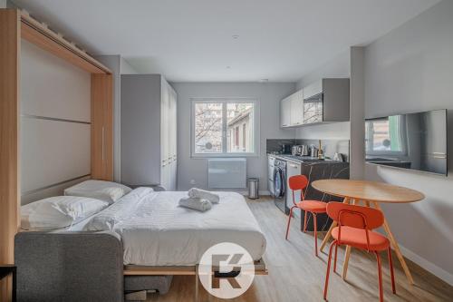 une chambre avec un lit, une table et des chaises dans l'établissement R'Apparts Latelier D'exception S2, à Grenoble