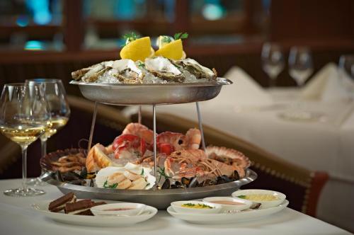 a plate of food on a table with glasses of wine at Hotel Schweizerhof Bern & Spa in Bern