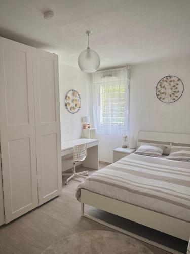 une chambre blanche avec un lit et un bureau dans l'établissement Pied-à-terre de rêve à Marseille - Confort & Style & moderne & équipé & cosy, à Marseille