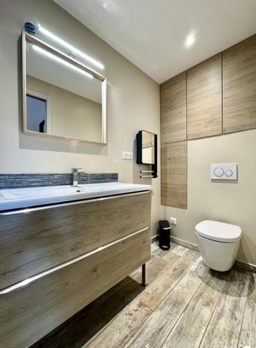 a bathroom with a tub and a toilet and a mirror at Les Flamants Roses La Capte T2 4 personnes 200m de la plage in Hyères