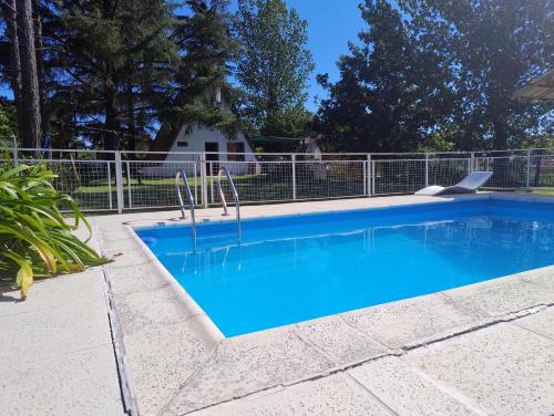 a swimming pool with blue water in a yard at Bungalow San Antonio in San Antonio de Arredondo