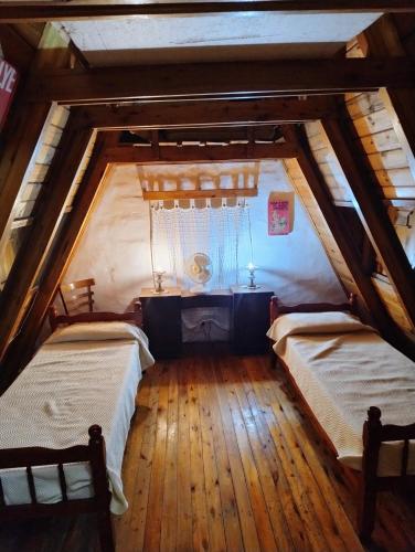an attic room with two beds and a table at Bungalow San Antonio in San Antonio de Arredondo