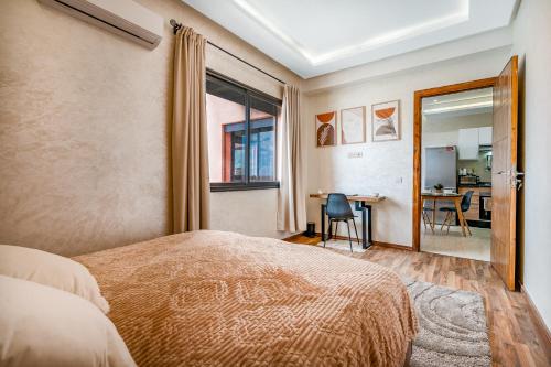 ein Schlafzimmer mit einem Bett und einem Tisch mit Stühlen in der Unterkunft Élégant avec Parking - Guéliz Hivernage in Marrakesch