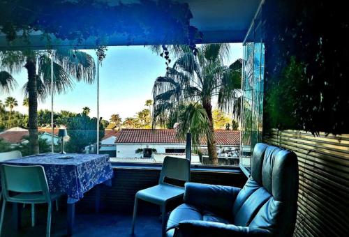 a living room with a table and chairs and a large window at Yumbo Tinache Luxury Maspalomas in Maspalomas