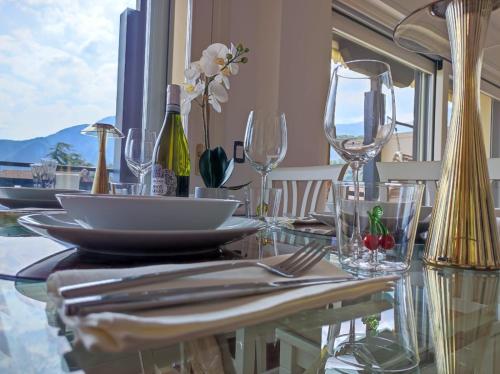 a dining table with glasses and plates on it at La Rosa del Lago in Lenno