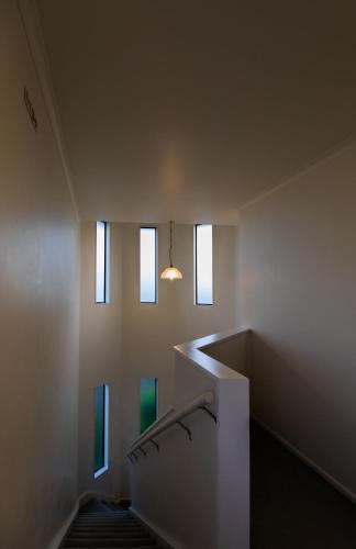 a staircase in a room with three windows at Camelot Motor Lodge and Conference Centre in Palmerston North